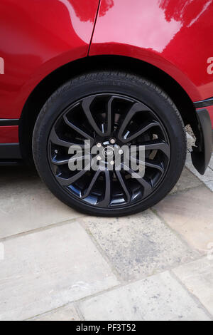 Range Rover Autobiography in Spectral Racing Red - ChromaFlair seen parked in old stone slab floored courtyard. Property released Stock Photo