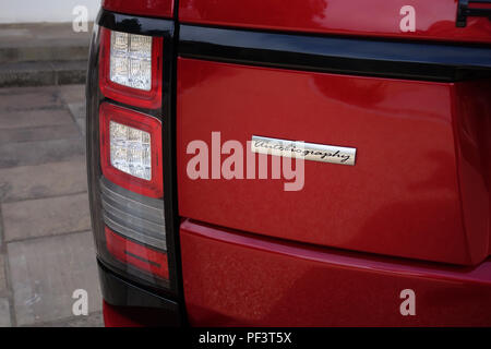 Range Rover Autobiography in Spectral Racing Red - ChromaFlair seen parked in old stone slab floored courtyard. Property released Stock Photo