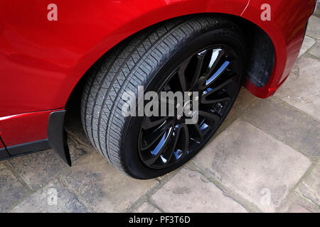 Range Rover Autobiography in Spectral Racing Red - ChromaFlair seen parked in old stone slab floored courtyard. Property released Stock Photo