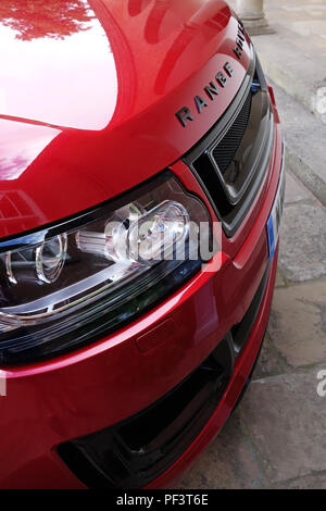 Range Rover Autobiography in Spectral Racing Red - ChromaFlair seen parked in old stone slab floored courtyard. Property released Stock Photo