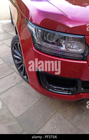 Range Rover Autobiography in Spectral Racing Red - ChromaFlair seen parked in old stone slab floored courtyard. Property released Stock Photo