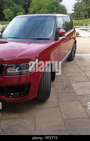 Range Rover Autobiography in Spectral Racing Red - ChromaFlair seen parked in old stone slab floored courtyard. Property released Stock Photo