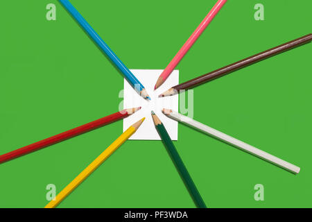paper note and colorful pencils lying on it Stock Photo