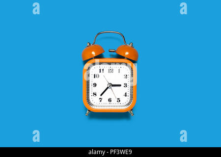 orange alarm clock on the blue background Stock Photo