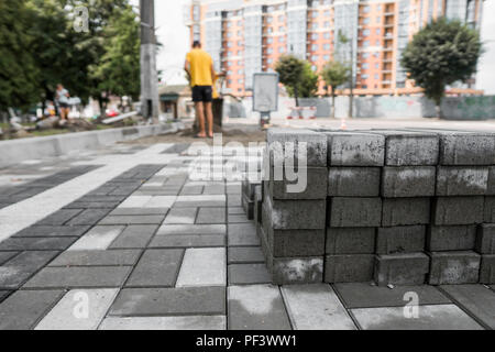 Pavement cobblestone in the stack on the street. Concrete or granite gray square pavement slabs for sidewalk construction. Industry manufacturing or building concept. Construction material Stock Photo