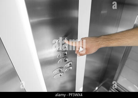 Forefinger pressing the fourth floor button in the elevator Stock Photo