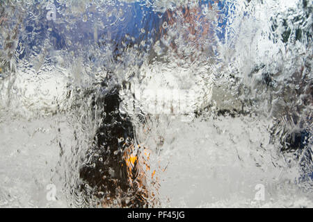 A woman walking in the rain - watery abstract background Stock Photo