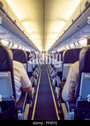 Saloon aircraft with passengers during the flight. Stock Photo