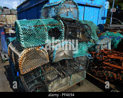 Some of the creels, lobster pots and other fishing paraphernalia stacked up on the pier at the small fishing village of Tarbert, Loch Fyne in Scotland. Stock Photo