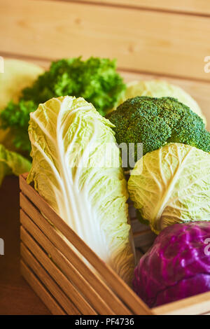 Different assortment of fresh raw cabbage in wooden box Stock Photo