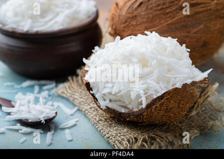 Coconut flakes in a shell on a blue background. Stock Photo