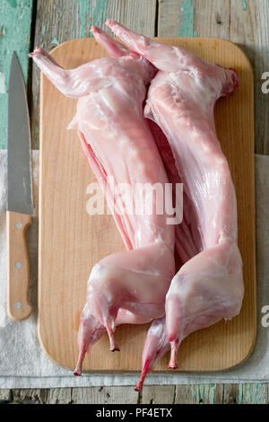 Two carcasses of young rabbits on a wooden board. Rustic style, selective focus. Stock Photo