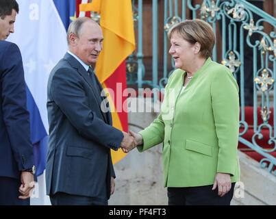 Meseberg, Germany. 18th Aug, 2018. German Chancellor Angela Merkel (R) shakes hands with visiting Russian President Vladimir Putin at the Schloss Meseberg, north of Berlin, Germany, on Aug. 18, 2018. German Chancellor Angela Merkel and Russian President Vladimir Putin held talks in north of Berlin on Saturday, with the topics ranging from Syria, Ukraine, Iran as well as the Nord Stream 2 gas pipeline project. Credit: Shan Yuqi/Xinhua/Alamy Live News Stock Photo