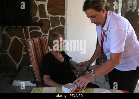 Mati, Greece. 18th Aug, 2018. A nurse of Hellenic Red Cross provides medical care to Ligeri Panagiotopoulou, one of the survivors of the July 23 wildfire in the seaside resort of Mati, 30 km east of Athens, Greece, Aug. 18, 2018. Red Cross volunteers have supported the search for dozens of missing people and comforted the survivors of the deadly forest fire. Credit: Marios Lolos/Xinhua/Alamy Live News Stock Photo