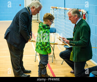 Haddington, UK. 19 August 2018.  The Royal Company of Archers, a ceremonial unit in Scotland stages a clout archery shoot as part of Haddington 700 events taking place during 2018 to celebrate the granting of a charter by Robert the Bruce to the town in 1318. John McMillan, East Lothian Council Provost and Lt Col Richard Callander OBE TD FRICS DL, secretary of the Company, show a ceremonial sword to a young boy wearing a Minecraft creeper hoodie Stock Photo