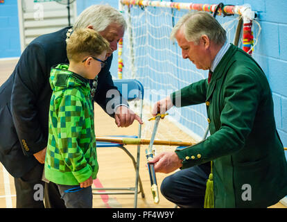 Haddington, UK. 19 August 2018.  The Royal Company of Archers, a ceremonial unit in Scotland stages a clout archery shoot as part of Haddington 700 events taking place during 2018 to celebrate the granting of a charter by Robert the Bruce to the town in 1318. John McMillan, East Lothian Council Provost and Lt Col Richard Callander OBE TD FRICS DL, secretary of the Company, show a ceremonial sword to a young boy wearing a Minecraft creeper hoodie Stock Photo