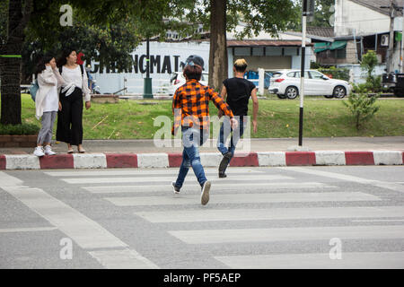 Chiangmai, Thailand - August  10 2018: Two Man Trying to cross the street directly across the crosswalk.  Photo on road in chiangmai city. Stock Photo