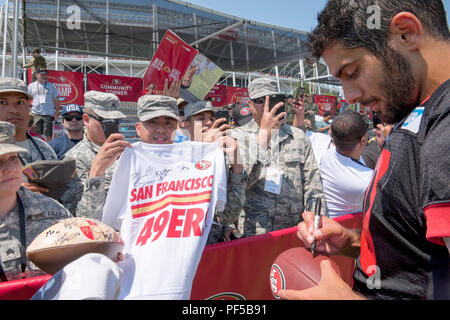 Jimmy Garoppolo, a 49ers quarterback, signs a football for a fan at their  training facility in