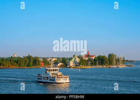 Helsinki harbor summer, evening view south from Helsinki harbour towards a small ferry ship passing the island of Valkosaari, Gulf of Finland. Stock Photo