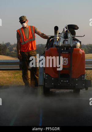 Senior Airman Stephen Runge, 9th Civil Engineer Squadron pavements and heavy equipment technician, operates a concrete saw Aug. 10, 2018, at Beale Air Force Base, California. Pavement and heavy equipment Airmen maintain the roads and flight line for Recce Town USA. (U.S. Air Force photo by Airman 1st Class Tristan D. Viglianco) Stock Photo