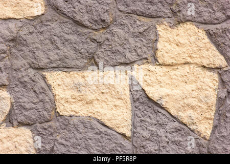 old stone wall background in multi-colored plaster Stock Photo