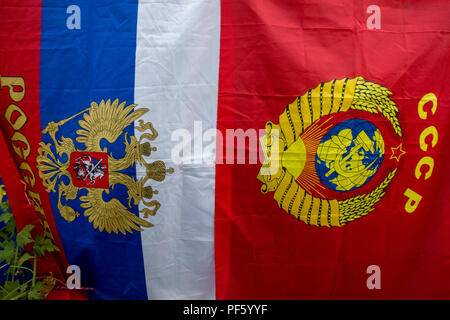 Flags of the Russian Federation and the USSR hang on a street in Russian town Stock Photo