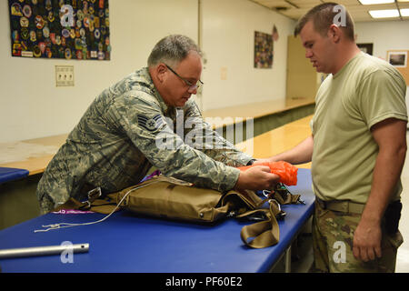 Tech. Sgt. Kurt Mellott and Staff Sgt. Stephen Falker, aircrew flight equipment technicians with the 193rd Special Operations Support Squadron, Middletown, Pennsylvania, Pennsylvania Air National Guard, build a Low-Profile Parachute from scratch Aug. 9, 2018. The new parachutes replaced the old ones, which were originally constructed in the 1980’s. (U.S. Air National Guard photo by Senior Airman Julia Sorber/Released) Stock Photo