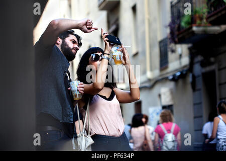 Trendy young couple taking photos on a smartphone, Barcelona, Spain. Stock Photo