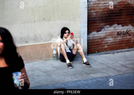 Young man using his smartphone, Gracia, Barcelona. Stock Photo