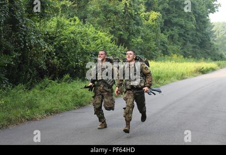 Spc. Tyler Gadapee, 21st Signal Brigade (left) and Pfc. Cameron Burgess, 911th Technical Rescue Engineering Company run to the finish of the 12-mile road march event on the final day of the 2018 U.S. Army Cyber Command Best Warrior Competition, Aug. 16, 2018. The winning Soldier and NCO competitors in the ARCYBER event will go on to compete in the Army level Best Warrior Competition. (Photo by Steve Stover) Stock Photo