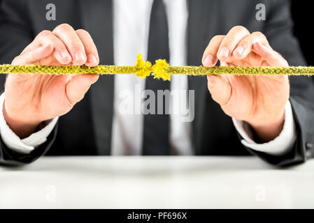 Closeup of business man holding defective rope. Business risk concept. Stock Photo