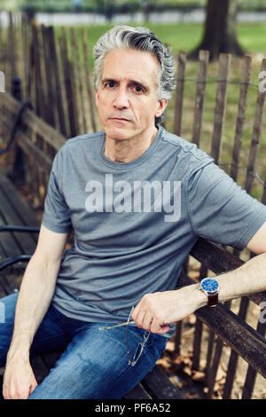 Grey Haired Man Sits on a Park Bench Stock Photo