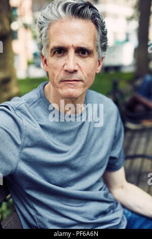 Grey Haired Man Sits on a Park Bench Stock Photo