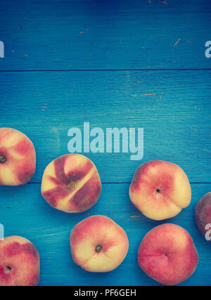 Tasty doughnut peaches on a blue rustic background, seasonal or healthy eating Stock Photo