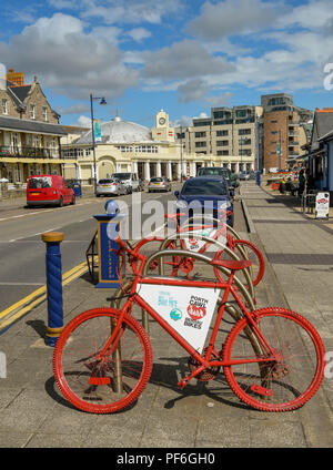 Red bicycles on the esplanade in Porthcawl Wales. The bike is available to hire as part of a bike rental scheme in the town. Stock Photo