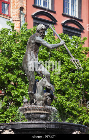 Neptune Fountain, bronze statue of the Roman God of the Sea against green tree in Old Town of Gdansk city in Poland Stock Photo