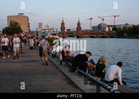 18 August 2018, Germany, Berlin: Numerous tourists go for a walk in the evening at dusk at the East Side Gallery on Oberbaumbrücke in Friedrichshain - Kreuzberg or sit on the Spree. Photo: Jens Kalaene/dpa-Zentralbild/dpa Stock Photo