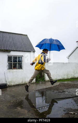 Ardara, County Donegal, Ireland weather. 20th August 2018.  A reflection of a man holding an umbrella in the rain on Ireland's north-west coast. Credit: Anna Hidalgo-Wayman/Alamy Live News Stock Photo