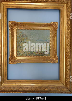 hanging artwork in one Two Gold picture frames with no pictures in the frames hanging on walls with plain background. Centre oval frame has a mirror. Stock Photo