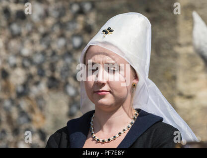 A young woman at an event dressed in traditional period medieval clothing, wearing a white Hennin with white veil, in Arundel, West Sussex, UK. Stock Photo