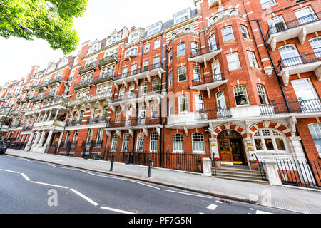London, UK - June 24, 2018: Neighborhood district of Kensington, street, old vintage historic traditional style flats, brick victorian architecture, r Stock Photo