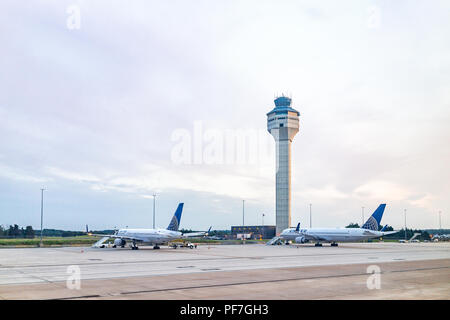 Dulles, USA - June 13, 2018: Dulles Internation Airport, IAD, control command center tower with United airplanes during sunset with view of air field  Stock Photo