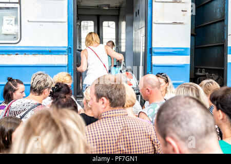 Lviv, Ukraine - August 1, 2018: Inside of Lvov train station platform with large crowd of many people waiting to board train car in historic Ukrainian Stock Photo