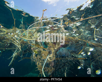 Big patch of ropes and garbage floating on the surface of the sea, shot from under water.