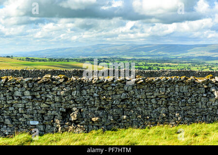 Limestone walls on Smardale Fell near Kirkby Stephen, Cumbria, with the Eden Valley, Cross Fell, and the North Pennines in the distance. Stock Photo