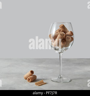 Wafer rolls in a glass - dessert for coctail on a gray table, background Stock Photo