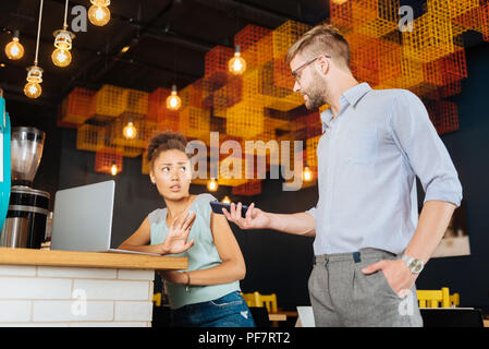 Dark-haired woman having no desire in talking by the phone Stock Photo