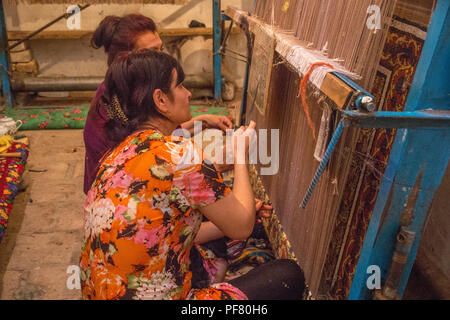 Uzbek women weaving traditional carpets in a workshop in Khiva  Uzbekistan, Silk Road, Central Asia Stock Photo