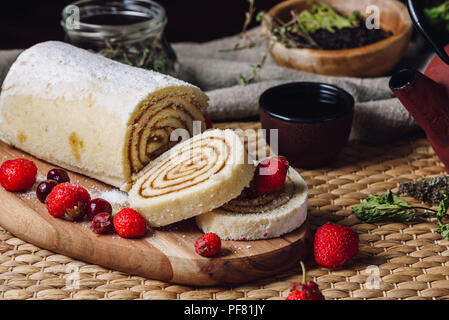 Apricot Paste Filled Roll for Dessert with Frozen Berries and Cup of Tea. Stock Photo