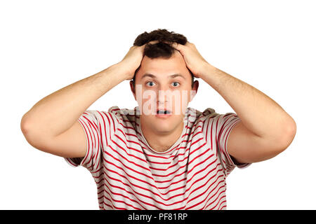 Shocked dazed young man in t-shirt holding head with both hands. emotional guy isolated on white background. Stock Photo